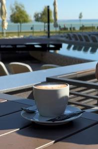 a cup of coffee sitting on top of a table at Premium Hotel Panoráma in Siófok