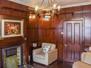 a living room with a chair and a fireplace at Heritage Lodge in Rhyl