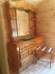 a wooden dresser with a mirror on top of it at Pennsylvania Glamping Destination for Nature Getaways for Four in Charming Log Cabin in Germania