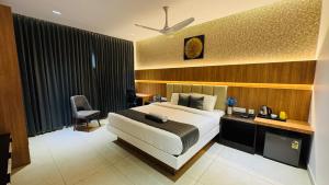 een slaapkamer met een bed, een bureau en een stoel bij Vaigai Residency in Salem