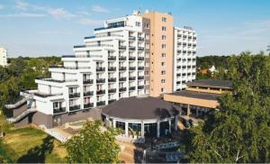 a large white building in front of a building at Premium Hotel Panoráma in Siófok