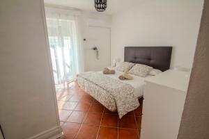 a bedroom with two beds and a large window at Casa Centro Los Remedios in Estepona