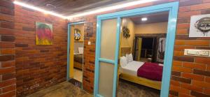 une pièce avec un mur de briques avec un lit dedans dans l'établissement Ashok Villa, à Mount Âbû