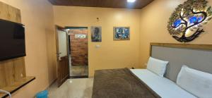 une chambre avec un lit et une télévision à écran plat dans l'établissement Ashok Villa, à Mount Âbû 7 autres photos