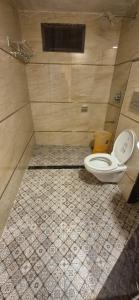 La salle de bains est pourvue de toilettes et de carrelage. dans l'établissement Ashok Villa, à Mount Âbû