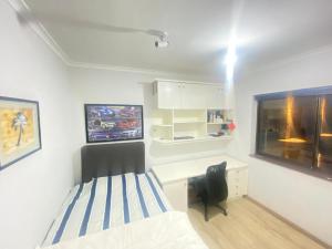 a bedroom with a bed and a desk and a window at Tranquil Garden Constantiaberg in Sweet Valley