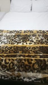 ロンドンにあるAwayHome Guest Roomsのベッドの上のヒョウ柄の毛布