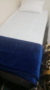 ロンドンにあるAwayHome Guest Roomsのソファの隣に青い枕が置かれたベッド