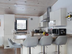 a kitchen with white cabinets and a counter with stools at Cruachan in Etteridge