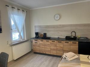 a kitchen with a counter and a clock on the wall at Pension am Görlitzbach in Münchenbernsdorf