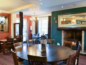 a dining room with a table and chairs and a fireplace at The Parade Apartment in Reighton