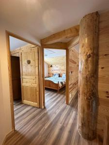 ein Schlafzimmer mit einem Bett und einem großen Baumstumpf in der Unterkunft Gîtes pour 2 à 6 personnes Manala et Vivala in Metzeral + 16 Fotos