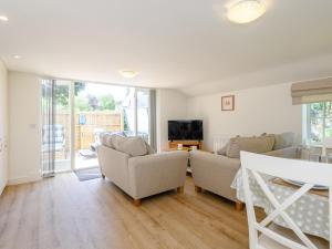 a living room with two couches and a television at The Chicken Coop in Fulletby