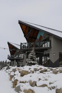 a building in the snow with a christmas tree in front at Котеджі Грань in Bukovel