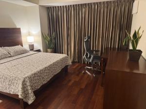 ein Schlafzimmer mit einem Bett, einem Schreibtisch und einem Stuhl in der Unterkunft Cinnamon Life Residencies- Luxury 2 Bedroom Apartment 12th Floor in Colombo + 42 Fotos