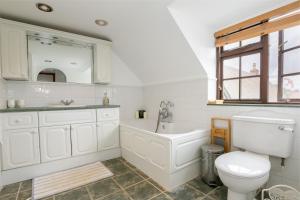 ein Badezimmer mit Badewanne, Toilette und Waschbecken in der Unterkunft Beautiful 5-Bedroom Home with Cinema & Games Room  + 20 Fotos