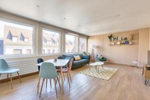 ein Wohnzimmer mit einer Couch und einem Tisch und Stühlen in der Unterkunft Appartement spacieux au cœur de Strasbourg in Straßburg