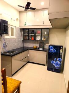 une cuisine avec un réfrigérateur avec des fleurs bleues dessus dans l'établissement Just Launched Cute Studio 2 BHK Flats in Kondpur Near Botanical Garden & Sarath City Capital Mall, à Kondapur