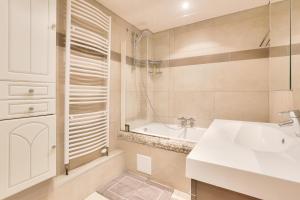 ein Badezimmer mit Waschbecken und Badewanne in der Unterkunft Appartement spacieux au cœur de Strasbourg in Straßburg + 5 Fotos