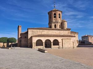 ein altes Gebäude mit einem Turm darauf in der Unterkunft Casa Cattleya in Almazán