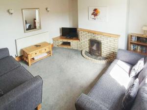 a living room with a couch and a fireplace at West End Farmhouse in Barmston