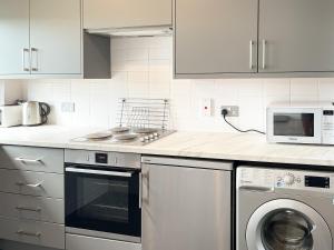 a kitchen with a stove and a microwave at Harvest Cottage in Padstow