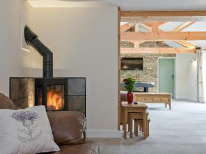 ein Wohnzimmer mit Couch und Kamin in der Unterkunft Eastlands Barn in East Barkwith