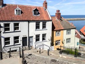 a group of buildings with the ocean in the background at Seacrest Cottage in Whitby