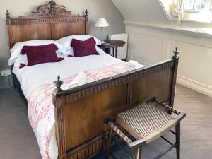 a bedroom with a large wooden bed and a bench at Seacrest Cottage in Whitby