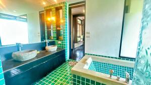 une salle de bain avec deux lavabos et un grand miroir dans l'établissement Montra Resort, à Nathon Bay 21 autres photos