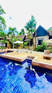 une piscine avec des carreaux bleus devant une maison dans l'établissement Montra Resort, à Nathon Bay