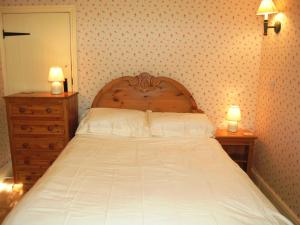 a bedroom with a large bed with two night stands at Thwaite Hill Cottage in Braithwaite