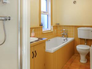 a bathroom with a tub and a sink and a toilet at Thwaite Hill Cottage in Braithwaite
