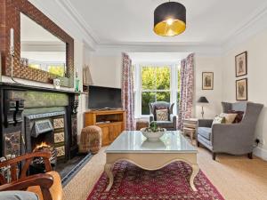 a living room with a fireplace and a table at Tremle in Penbryn +26 photos