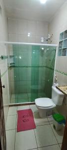 a bathroom with a toilet and a glass shower at Casa do sossego - conforto, praia, piscina in Maricá