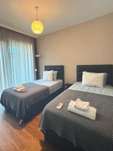 a hotel room with two beds with towels on them at Cyprus Sunbay Retreat in Ayia Napa