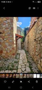 a screenshot of an alley with a stone wall at Airb nb Zachlorou in Kalavrita
