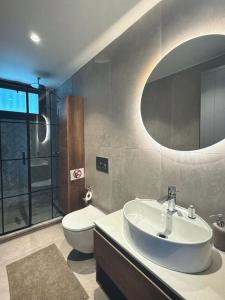 a bathroom with a sink and a toilet and a mirror at Cyprus Sunbay Retreat in Ayia Napa