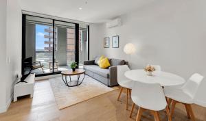 a living room with a couch and a table at Deluxe apartments in the heart of South Melbourne in Melbourne