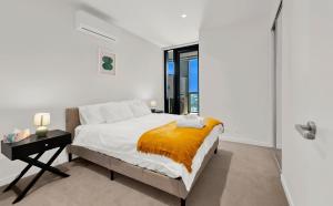 a white bedroom with a bed and a window at Deluxe apartments in the heart of South Melbourne in Melbourne +36 photos