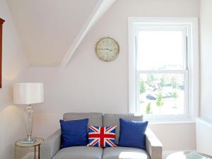 a living room with a couch and a clock on the wall at Skyfall in Canterbury