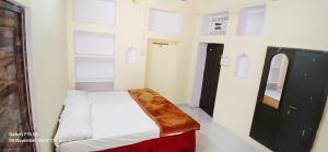 a small room with a bed and a mirror at Divya ganga hotel in Varanasi