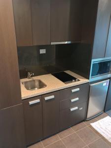a small kitchen with a sink and a stove at Cozy 1 Bed Apartment - 2 Min to Queen VIC Market in Melbourne