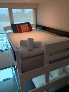 a bed in a room with a glass floor at Cozy 1 Bed Apartment - 2 Min to Queen VIC Market in Melbourne