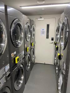 a row of washing machines in a laundry room at Cozy 1 Bed Apartment - 2 Min to Queen VIC Market in Melbourne +16 photos