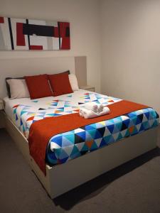 a bedroom with a bed with a colorful comforter at Cozy 1 Bed Apartment - 2 Min to Queen VIC Market in Melbourne