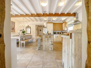a large kitchen with wooden ceilings and a table at The Water Mill in Bradbourne