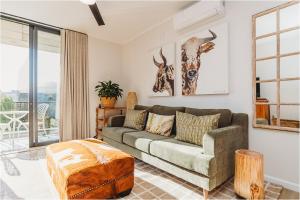 ein Wohnzimmer mit Sofa und Tisch in der Unterkunft 201 The Meadows Stunning Mountain Views in George + 39 Fotos