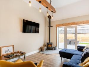 Una sala de estar con un sofá y una chimenea. en Dip Tub Den - Uk35989, en Wansford