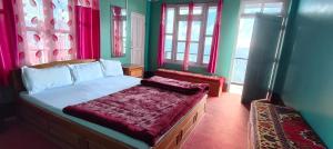 a bedroom with a bed and two windows at Chander Pahar Retreat in Kalimpong